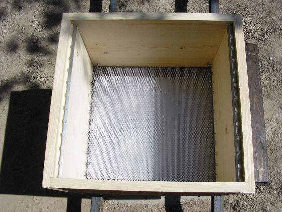 Vue de dessus de la ruche vide, le fond est grillagé pour que les déchets tombent dans le tiroir